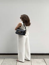 A woman wears a pair of high-waisted pants